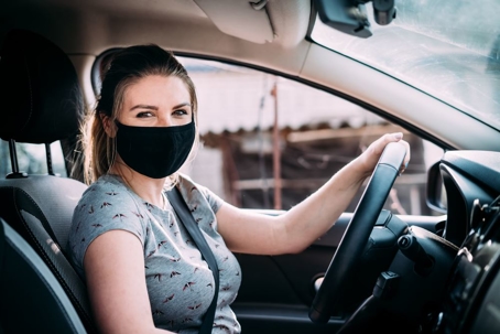girl in facemask in car
